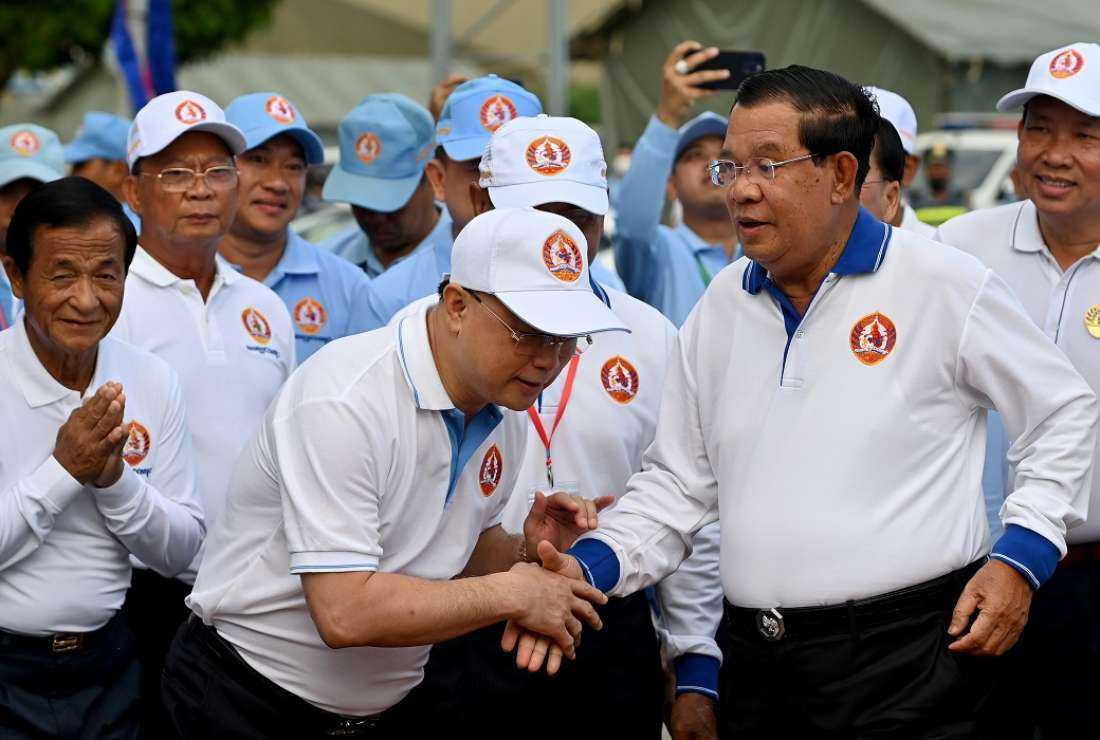 Cambodia's Prime Minister Hun Sen (R) shakes hands with supporters during a July 1 rally for the ruling Cambodian People's Party ahead of the upcoming election in Phnom Penh on July 23. Seventeen members of the outlawed Cambodian National Rescue Party have been banned from appearing on voter lists at elections for up to 25 years following allegations they were encouraging voters to spoil ballot papers in the upcoming poll
