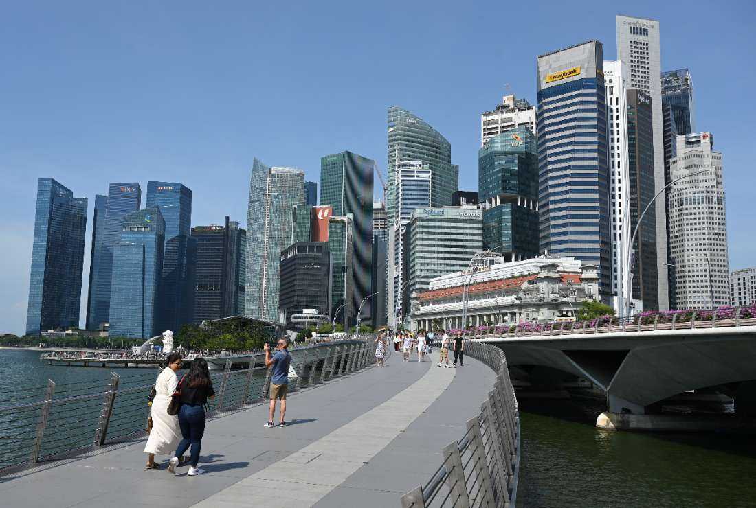 People walk across Jubilee Bridge on Marina Bay in Singapore on May 25
