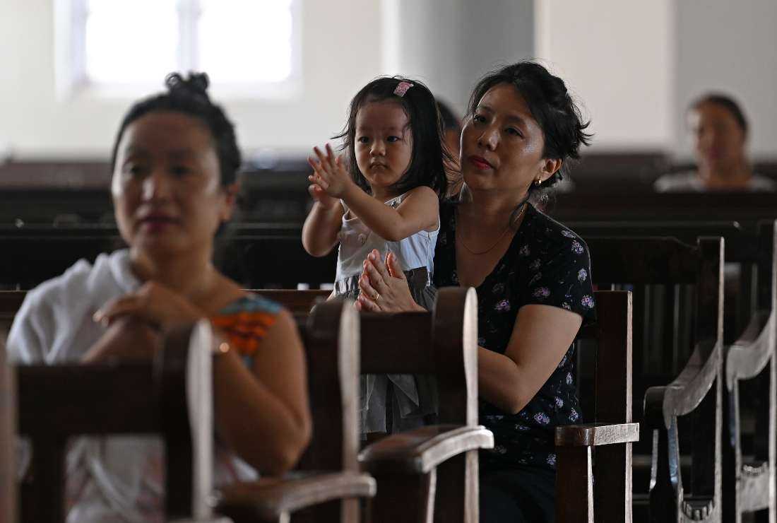 A woman along with her child attends the Children's Mass at Baptist Convention Center church in Imphal on July 23