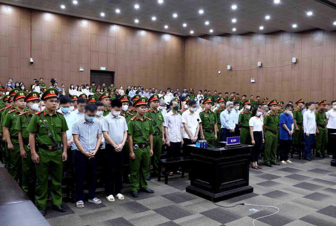 This picture taken and released by the Vietnam News Agency (VNA) on July 28 shows defendants (in civil shirts) standing for sentencing in a Hanoi courtroom for the repatriation flight trial