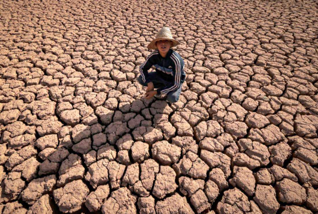 A child crouches over cracked earth at al-Massira dam in Ouled Essi Masseoud village, some 140 kilometres (85 miles) south from Morocco's economic capital Casablanca