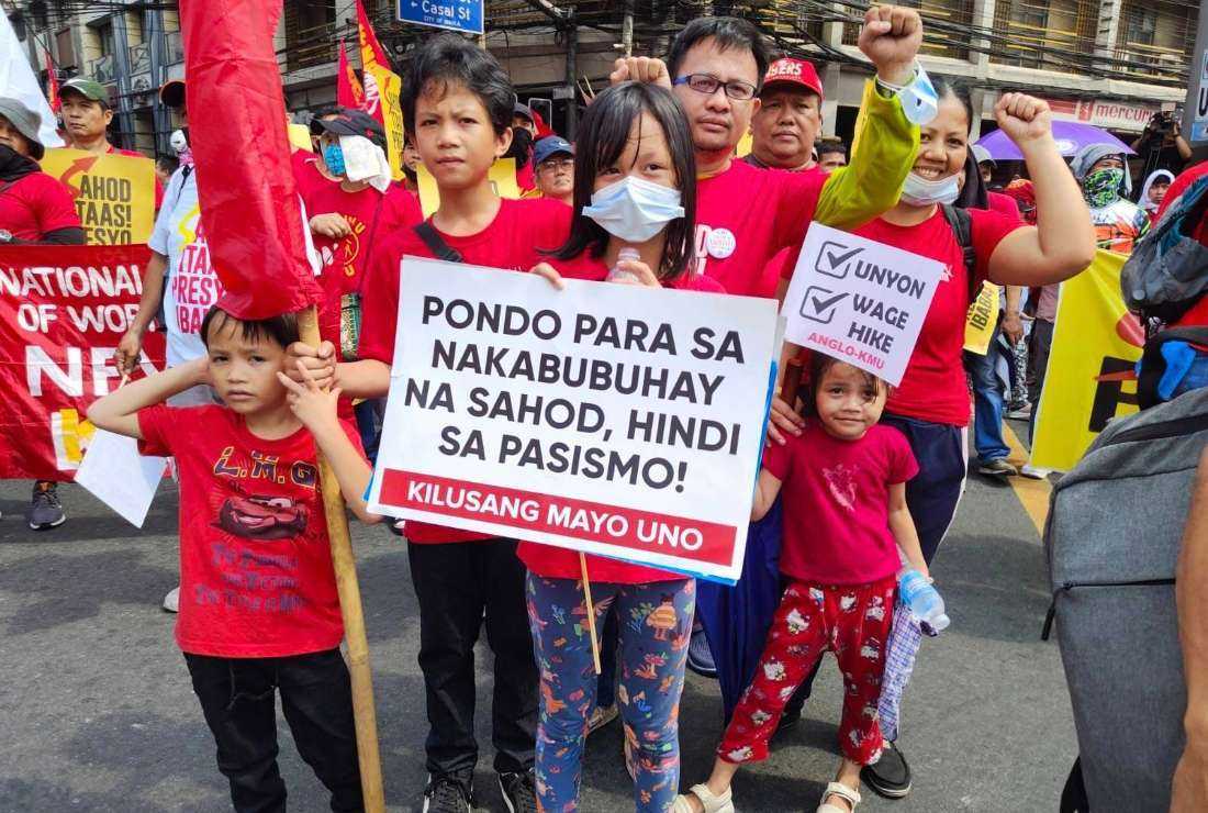 Filipino workers with their family members join a march in the capital Manila to call for a minimum wage rise