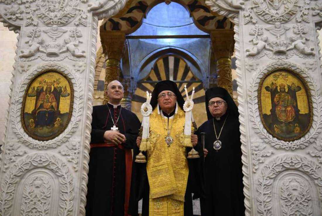 Patriarch of the Melkite Greek Catholic Church Youssef Al Absi, center, leads prayers during the re-opening of the Greek Catholic Church of Our Lady, in Aleppo in 2019