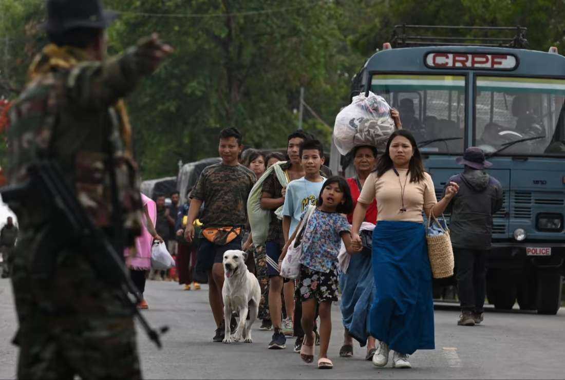 People fleeing violence prepare to board a paramilitary truck in Churachandpur, near Imphal, the state capital of Manipur state in India in May