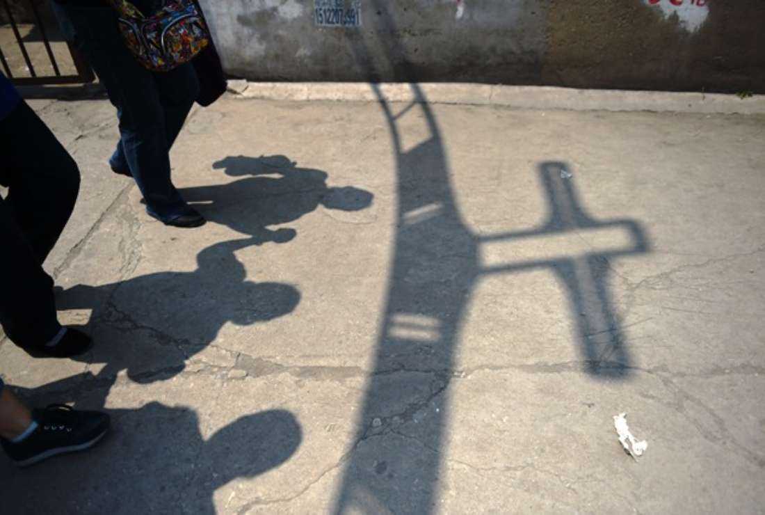 Worshippers walking past the shadow of a cross at the entrance to the 'underground' Zhongxin Bridge Catholic Church, after a service celebrating the Feast of the Ascension in Tianjin, 110 kilometers (68 miles) from Beijing, in this file photo