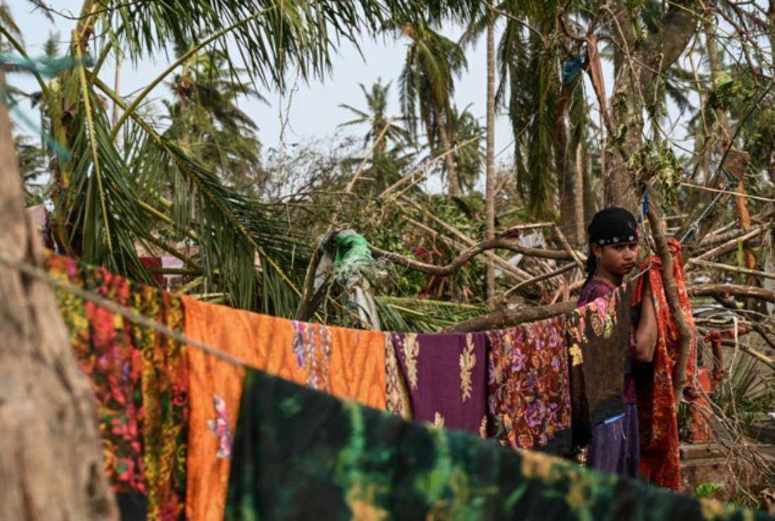 A girl hangs clothes at a refugee camp in Sittwe on May 16 after cyclone Mocha made a landfall. To add to the misery of the affected people, flash floods triggered by incessant heavy rains since last week have displaced many people in western and southern Myanmar