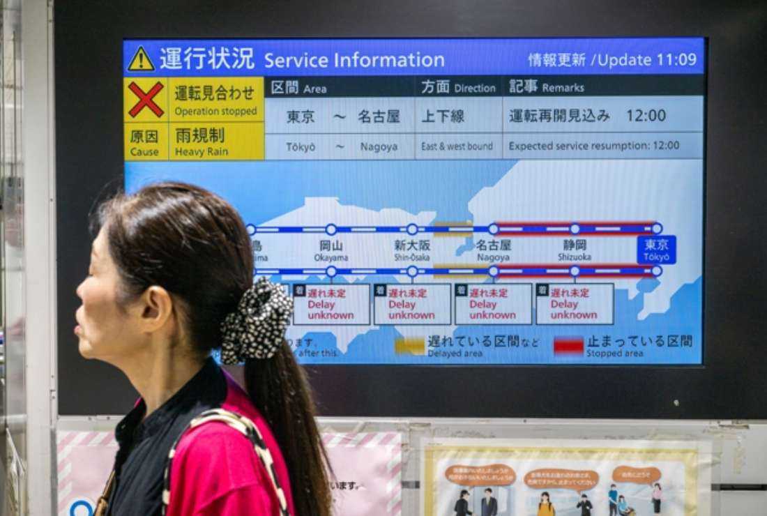 A passenger waits in front of a train service information board for the bullet train, or 'Shinkansen,' in Tokyo Station on June 3