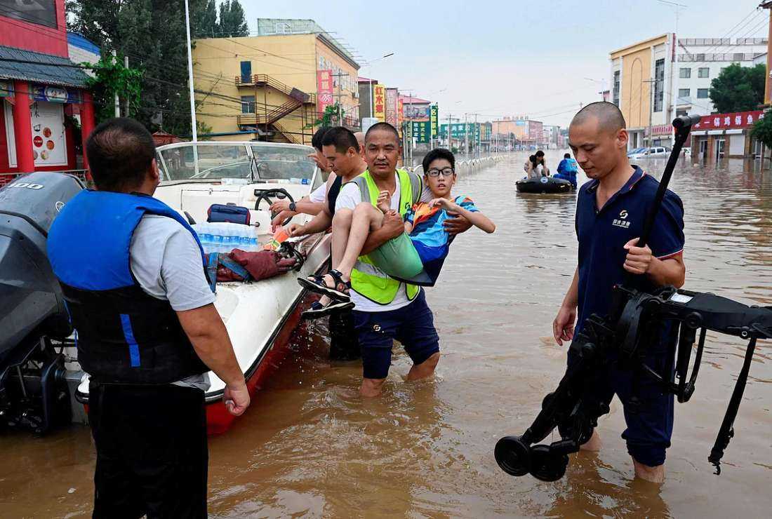 Rescue personnel evacuate residents from a flooded area following heavy rains in Zhuozhou, in northern China’s Hebei province on Aug 2, 2023