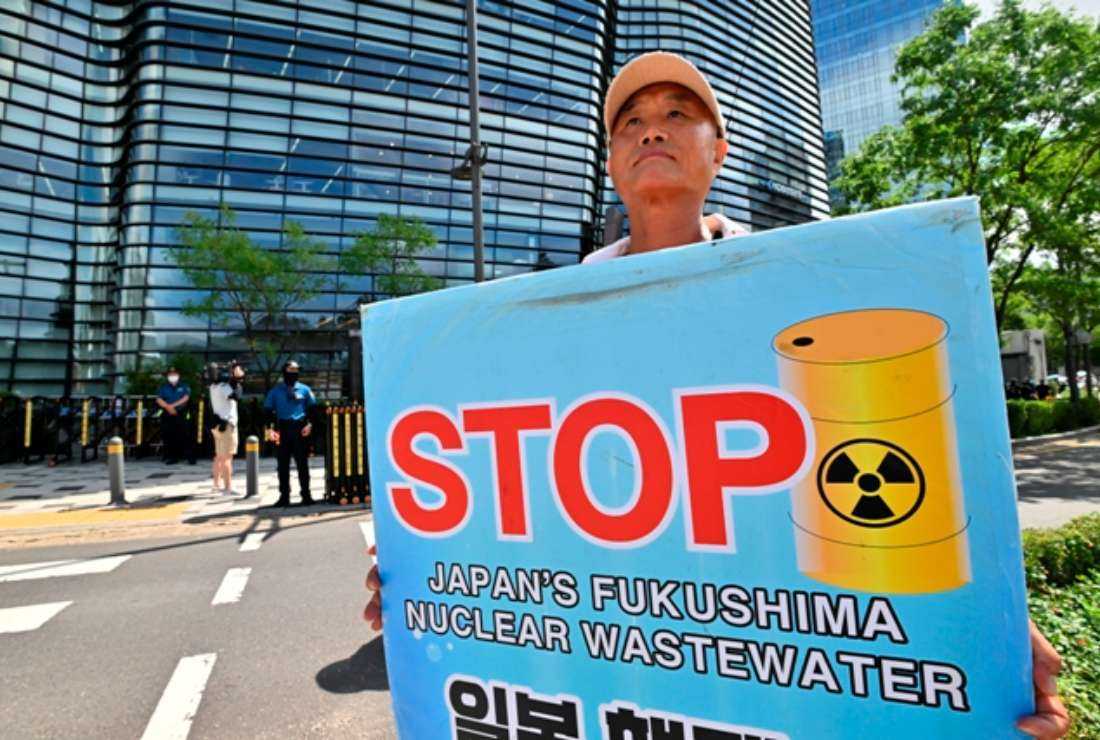 A South Korean man holds a placard in front of a building housing the Japanese embassy in Seoul on Aug. 24, as protesters gather to demonstrate against Japan's discharge of treated wastewater from the crippled Fukushima nuclear plant