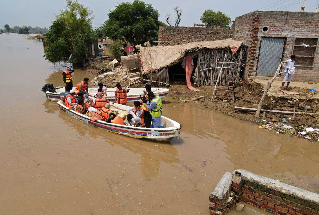 Rescue workers help victims of the flood-affected area in Bhikhiwind village of Kasur district on Aug. 22