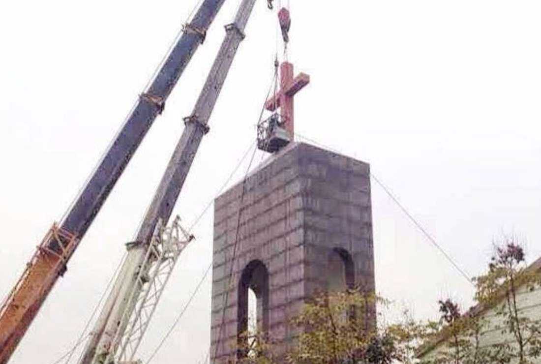 Authorities tear down a cross from a Protestant church in Hangzhou's Dingqiao township in China on Dec. 19, 2014