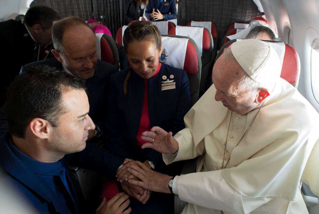 A handout picture released by the Vatican press office Osservatore Romano showing Pope Francis (right) marrying Latam airline flight attendants Paula Podest (center) and Carlos Ciuffardi (foreground) during the flight between Santiago and the northern city of Iquique on Jan. 18, 2018, as their witness, Chilean businessman and one of the owners of the airline, Ignacio Cueto (second-left), looks on