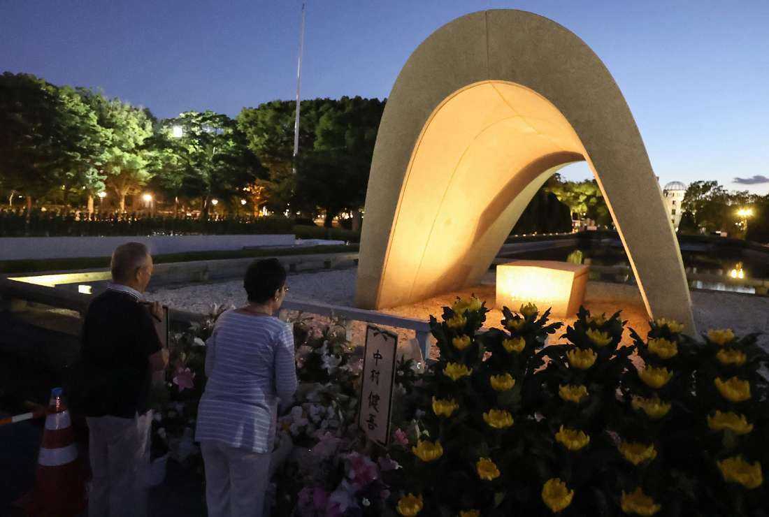 People visit and say prayers at sunrise at the cenotaph for the atomic bomb victims at the Peace Memorial Park in Hiroshima on August 6, 2023, to mark the 78th anniversary of the world's first atomic bomb attack