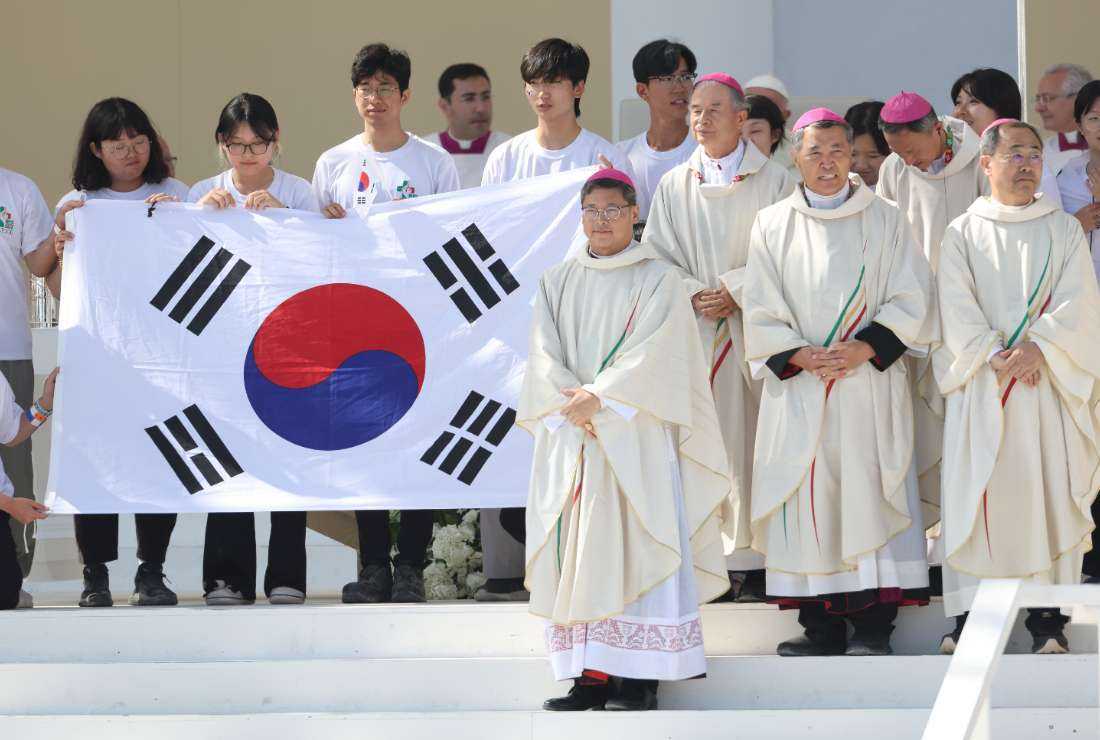 Pilgrims and bishops pose for a group picture on stage holding a South Korean flag, as the next WYD is to be held in Seoul, during the closing mass of the World Youth Days (WYD) in Tejo Park, Lisbon, on Aug. 6