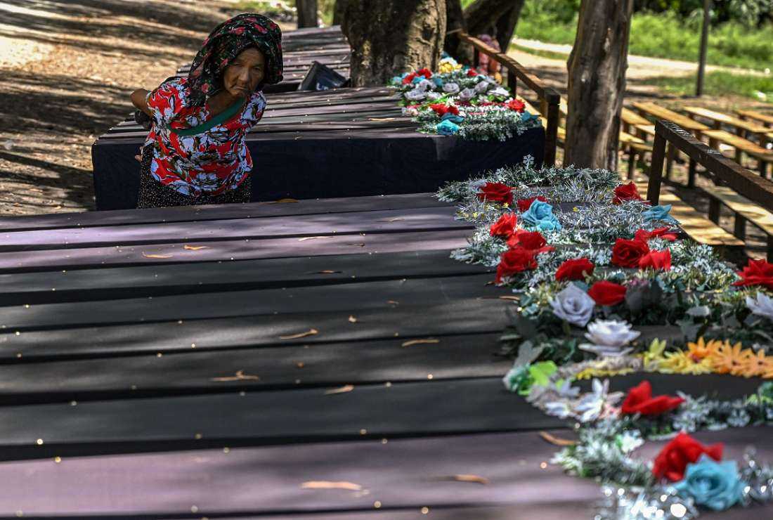 In this picture taken on July 24, 2023, an elderly woman looks at empty coffins kept at a makeshift memorial made for the victims who lost their lives during the ethnic violence in Churachandpur district in the northeastern Indian state of Manipur