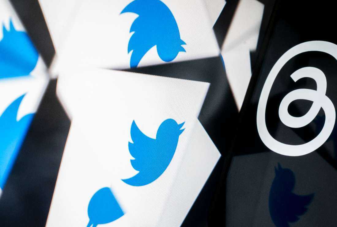 This photo illustration created in Washington, DC, on July 5 shows the Twitter logo reflected near the logo for Threads, an Instagram app owned by tech giant Meta. The company has removed thousands of troll accounts originating in China for violating its policy against coordinated inauthentic behavior