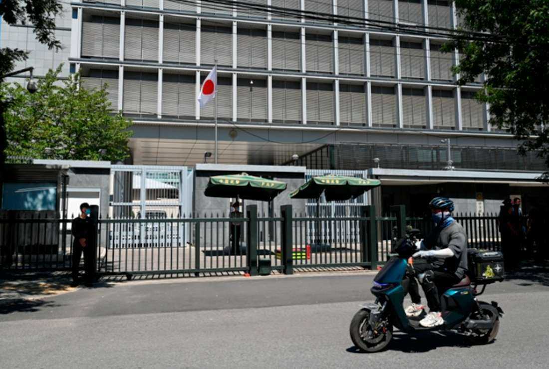 A man rides his motorcycle past the entrance of the Japanese embassy in Beijing on Aug. 29. Japan said that harassment being faced by the Japanese in China after the release of water from the Fukushima nuclear plant was 'extremely regrettable,' confirming that a brick was thrown at the country's embassy in Beijing