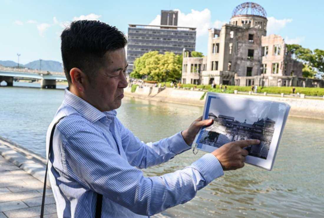 Hiroshi Yamaguchi, whose company offers a virtual reality tour allowing people to experience the city of Hiroshima as it was before, during and after the atomic bomb attack, during a tour of the city on May 15. An American YouTuber was arrested Sept. 22 for posting provocative videos including those on Hiroshima and Nagasaki. 