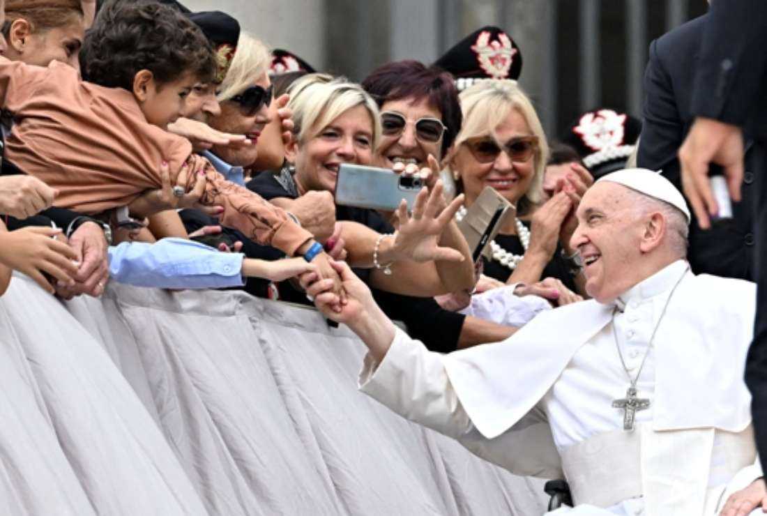 Pope Francis greets a child at the end of a private audience with Carabinieri officers at the Vatican on Sept. 16.