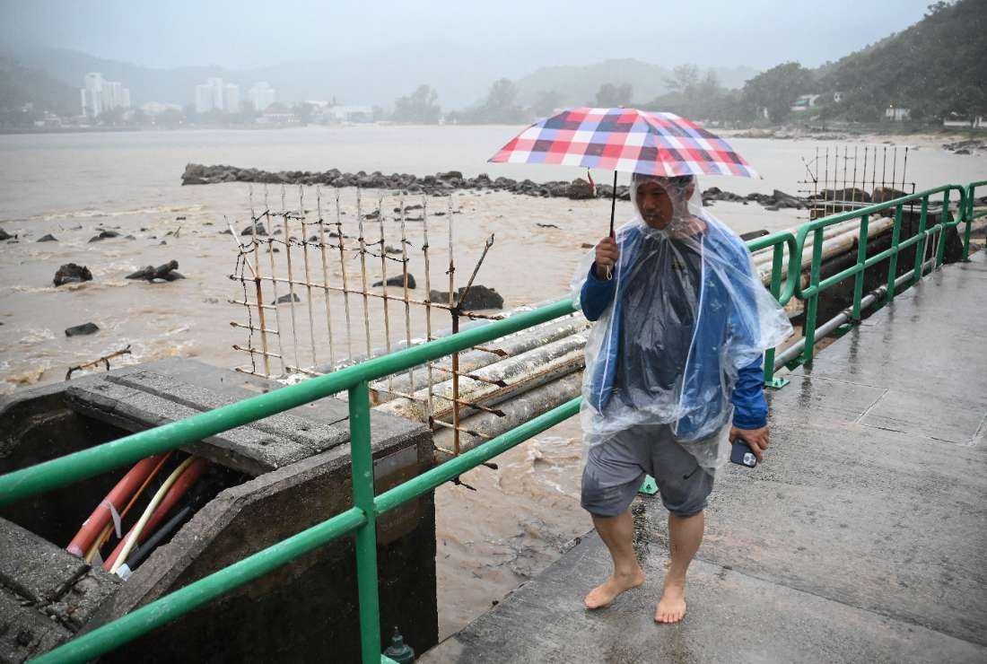 A man walks on a bridge over a swollen river on Lantau Island in Hong Kong on Sept. 8