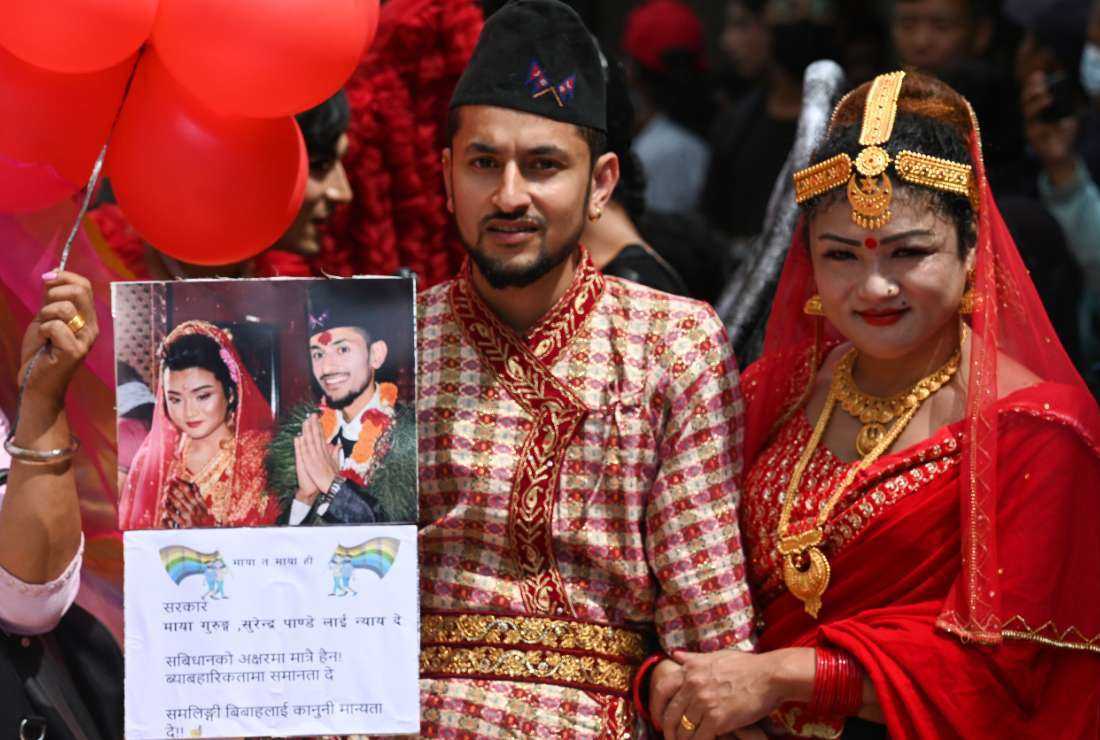 Nepal’s same-sex couple Maya Gurung (right) and Surendra Pandey (left) wearing traditional attire take part in a Pride Parade in Kathmandu on Aug. 31