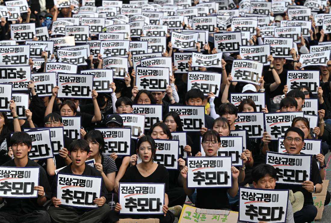 A photo taken on Sept. 4 shows protesters holding up signs reading 'Revealing the truth is the way to pay respect'during a rally demanding the protection of teachers' rights in front of the National Assembly in Seoul, as they commemorate an elementary school teacher who died in an apparent suicide in July