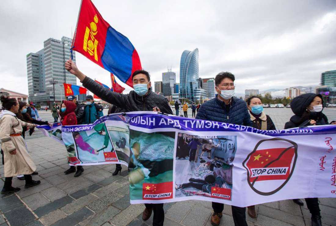 Protesters hold banners and wave the Mongolian flag during a protest in Ulaanbaatar, the capital of Mongolia, against Chinese policies in the neighboring Chinese province of Inner Mongolia on Oct. 1, 2020