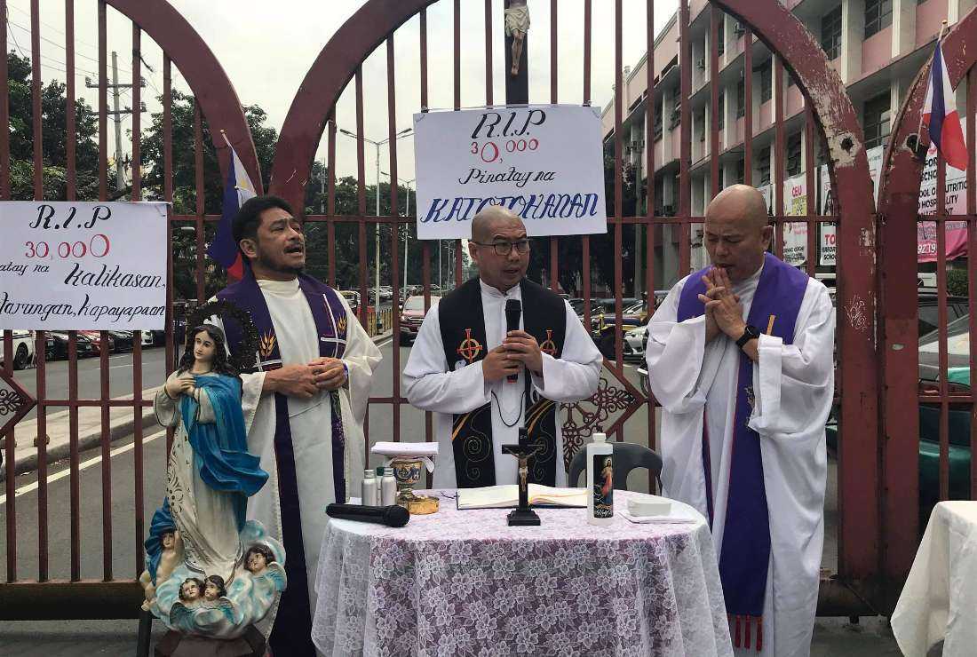 Father Albert Alejo (left) and Father Flavie Villanueva (center) celebrate Mass for the victims of deadly anti-drug crackdown during the rule of former President Rodrigo Duterte