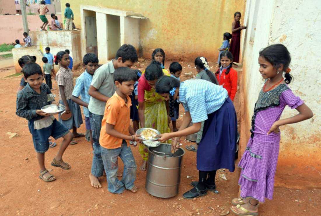 Indian school children attending a government school line-up for the mid-day meal outside their classrooms near lavatories in Bangalore on July 19, 2013. In Tamil Nadu state, meals and education benefits are denied to students at schools run by Christians and other private groups, says the Committee for Redeeming Rights of Minority and Non-Minority Government-Aided Schools.