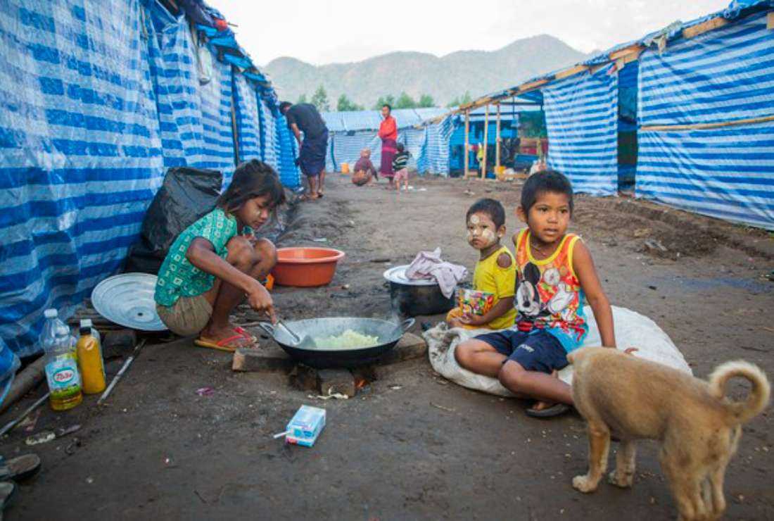 Myanmar refugee children, who fled a surge in violence as the military cracked down on rebel groups in February 2022, cook at a camp near the Myanmar-Thailand border in Kayin state
