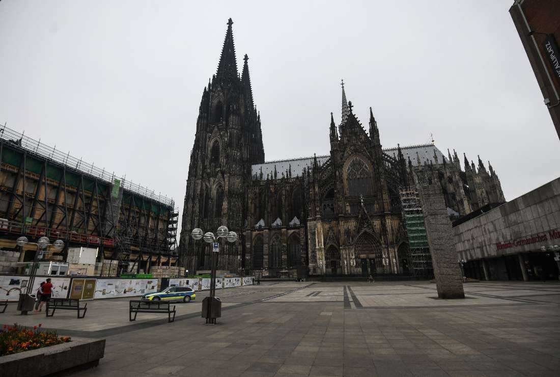 A police car is seen on the almost empty square in front of the Cologne cathedral in Cologne, western Germany, on April 19, 2020, amid the novel coronavirus pandemic.