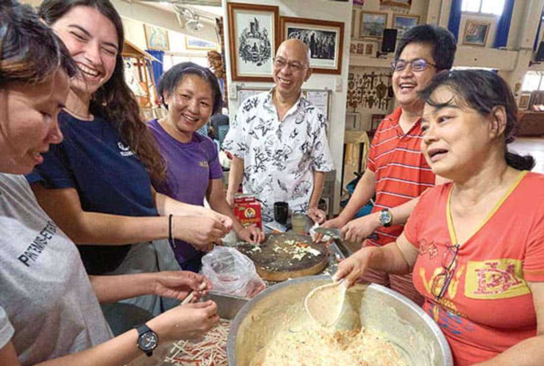 In Taichung, Taiwan, Maryknoll Father Joyalito Tajonera (center) and volunteers prepare a meal in the Ugnayan shelter he founded, which is run like a Catholic Worker house