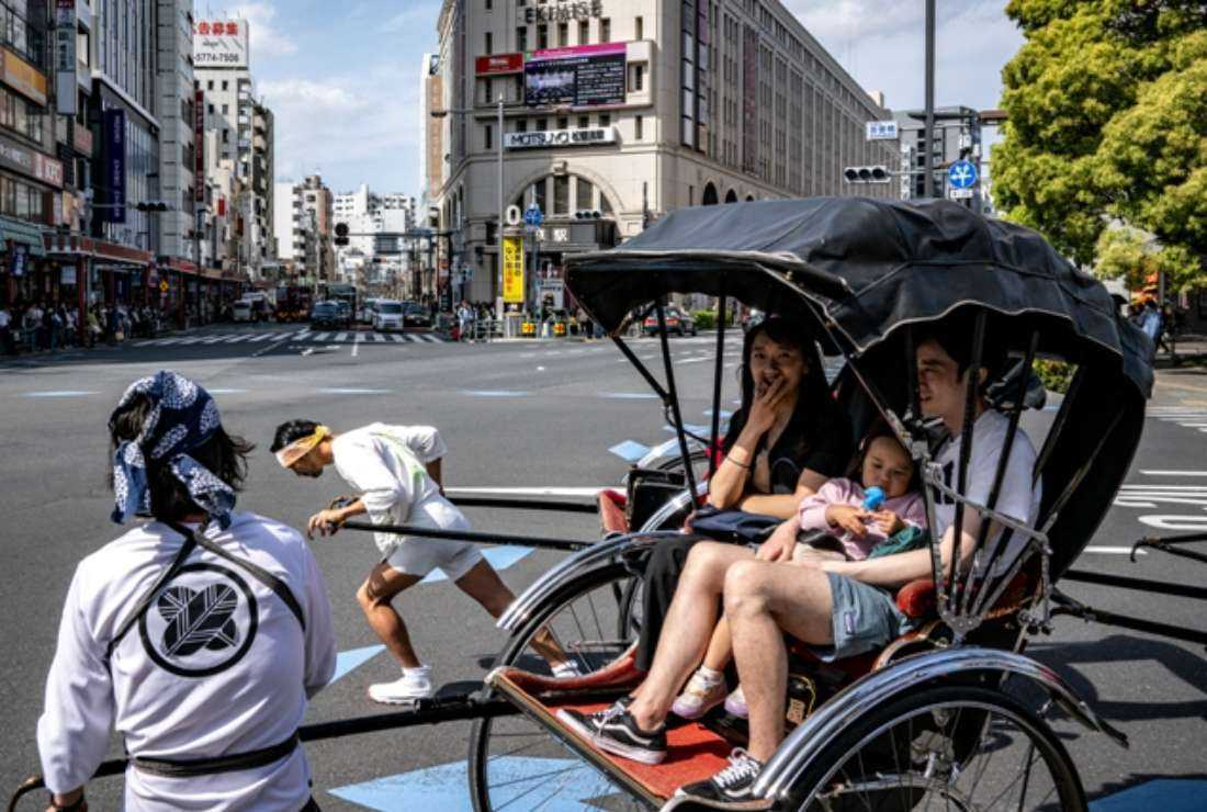 A family rides a Japanese rickshaw, a traditional two-wheeled passenger cart, near Sensoji Temple, a popular tourist attraction, in Tokyo on April 29. The overall birth rate in Japan has been experiencing a decline and there has been a noticeable surge in the number of individuals choosing to give birth at older ages, according to the Ministry of Health, Labor and Welfare's demographic statistics. 