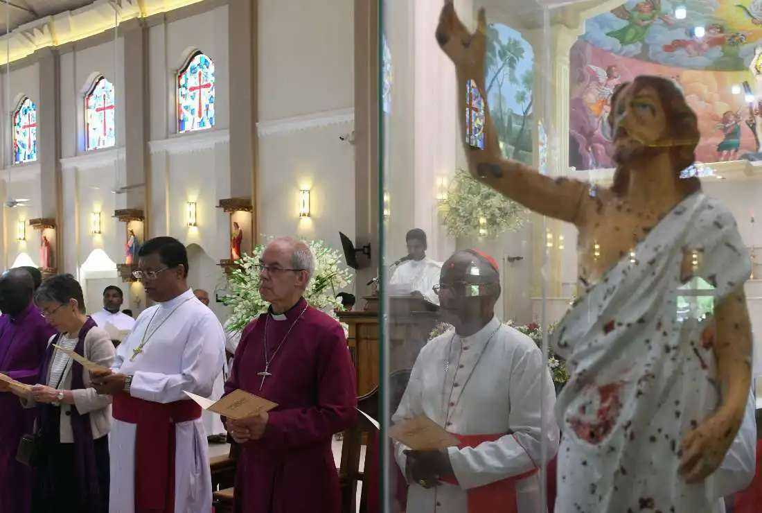 This picture taken on Aug. 29, 2019, shows Archbishop of Canterbury Justin Welby (center) and Cardinal Malcolm Ranjith (right) paying homage to the victims of the Easter Sunday bombings during a visit to St. Sebastian's Church in Negombo, north of the capital Colombo