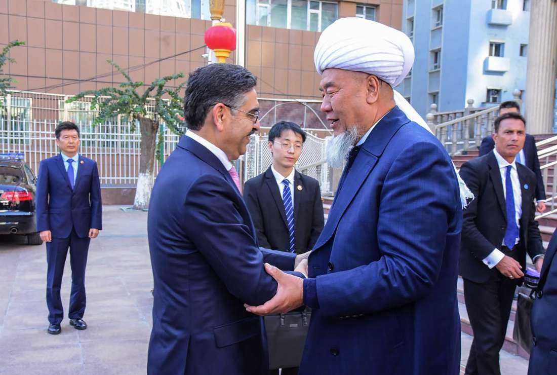 This handout picture taken on Oct. 20 and released by Pakistan's Prime Minister Office shows the Imam of Yanghang Mosque Abdureqip Tumulniyaz (right) greeting Pakistan's caretaker Prime Minister Anwaar-ul-Haq Kakar (left) on his arrival at Yanghang mosque in Urumqi, in China’s Xinjiang province.