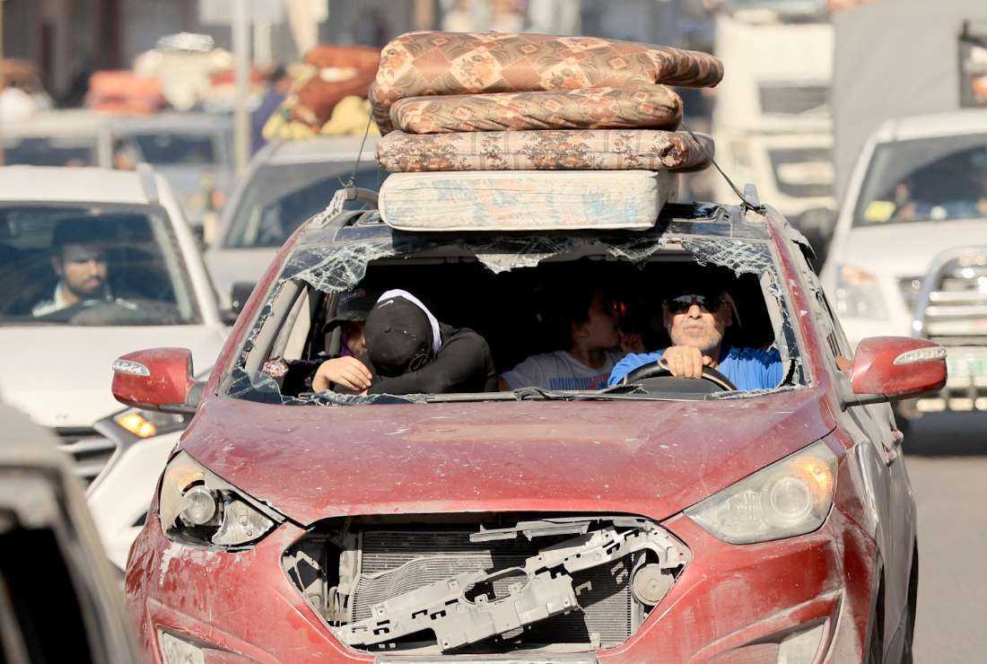 Riding in a damaged vehicle a Palestinian family flees with hundreds of others following the Israeli army's warning to leave their homes and move south before an expected ground offensive, in Gaza City on Oct. 13.