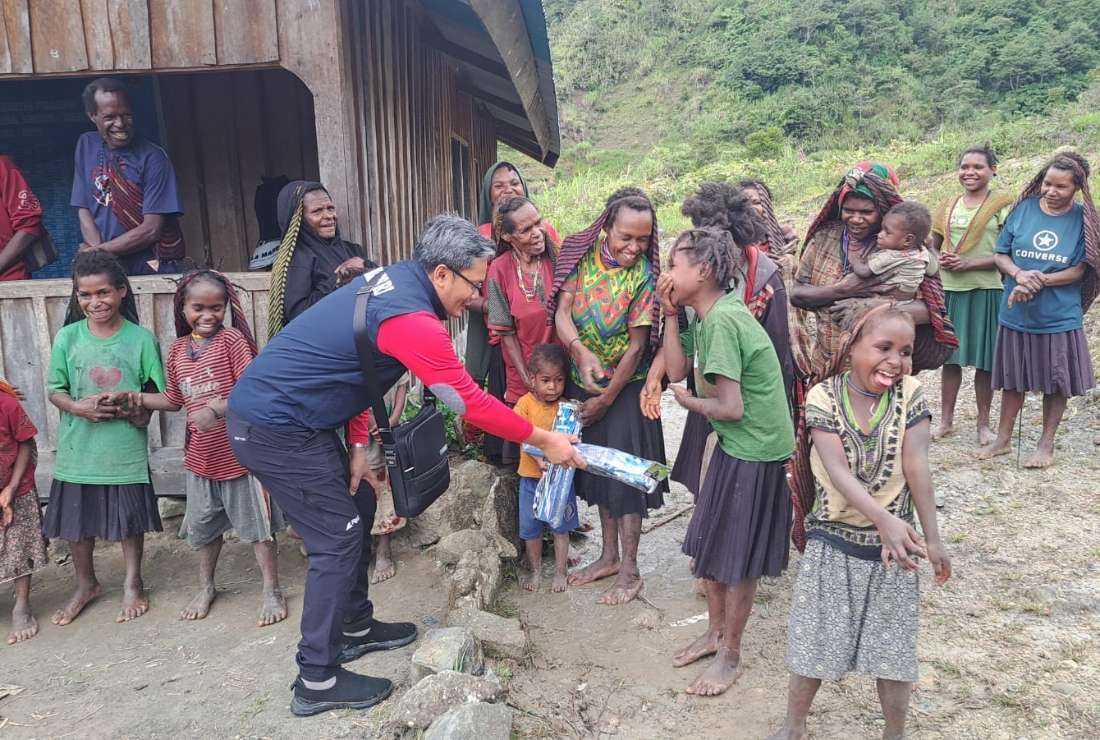 A government official from the Ministry of Social Affairs is seen with children in Yahukimo Regency, Papua while distributing aid to hungry residents, in collaboration with church groups.
