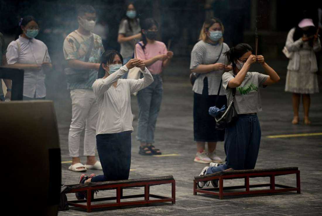 Young people offer prayers at Yonghe Temple, popularly known as Lama Temple, in Beijing in 2022.