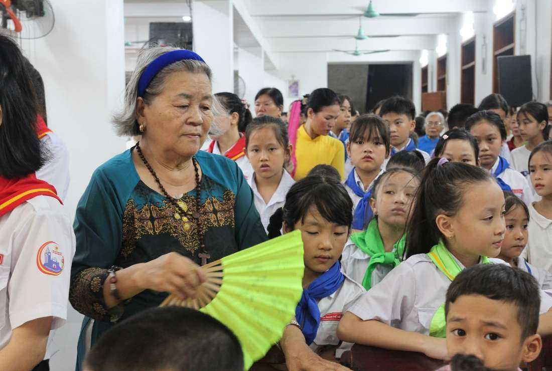 Mary Tran Thi Tam fans catechism students at Nghia Lo Church on Sept. 9.