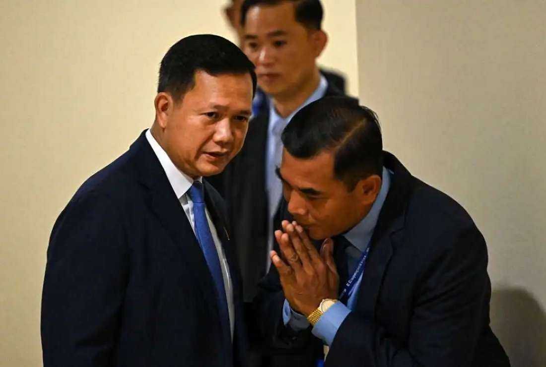Cambodian Prime Minister Hun Manet (L) speaks with a bodyguard as he attends a parliamentary meeting at the National Assembly building in Phnom Penh on Aug 22, 2023.
