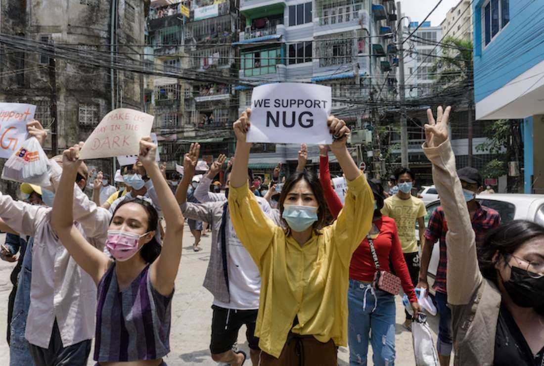  Protesters hold signs in support of the National Unity Government (NUG) during a demonstration against the military coup in Yangon’s Sanchaung township on April 27, 2021. 