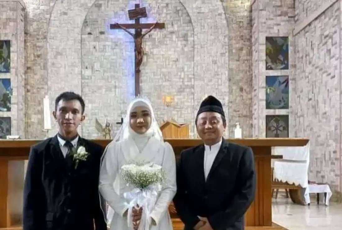 Ahmad Nurcholish, right, an interfaith marriage counselor with the Indonesian Conference on Religion and Peace, poses for a photo with an interfaith couple in this file image