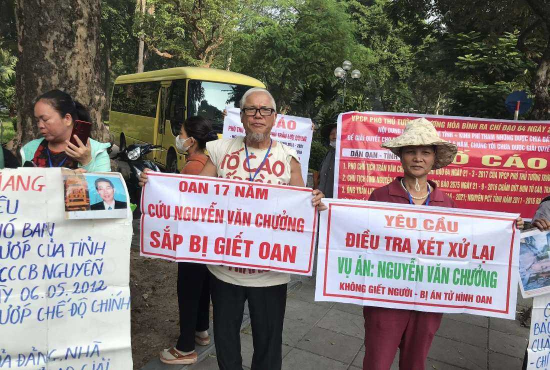 Nguyen Truong Chinh and his wife (right), parents of the death row prisoner Nguyen Van Chuong, hold banners calling on people to save their son in Hanoi in an undated photo