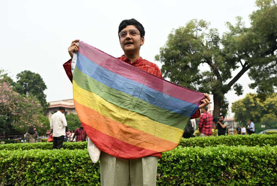 An activist holds a rainbow flag in the courtyard of India’s Supreme Court in New Delhi on Oct. 17