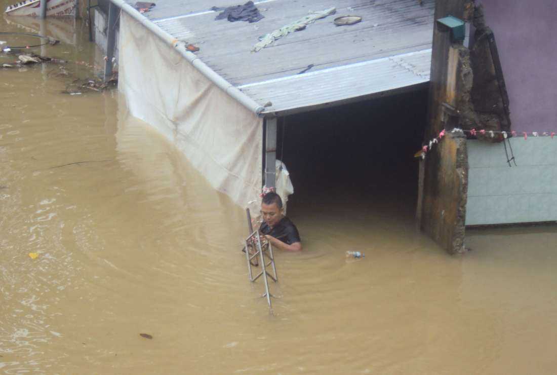 Hue province resident Nguyen Hua tries to protect his furniture from washing away on Nov. 17.