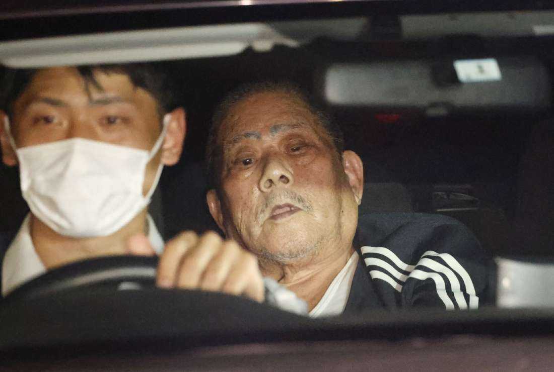 Suspect Tsuneo Suzuki (right), who barricaded himself in a post office, is transferred by a police vehicle in Warabi city, Saitama prefecture on Oct. 31.