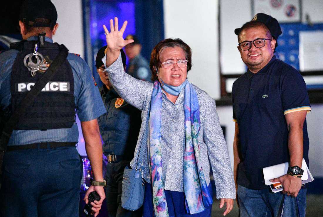 Former Philippine senator and human rights campaigner Leila de Lima (center) waves at the media as she leaves the police custodial center at Camp Crame in Manila on Nov. 13