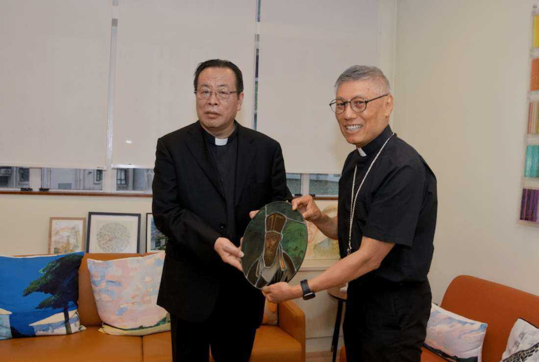 Archbishop Joseph Li Shan of Beijing (left) hands over an image of pioneering Italian Jesuit missionary Matteo Ricci to Cardinal Stephen Chow of Hong Kong on Nov. 13.