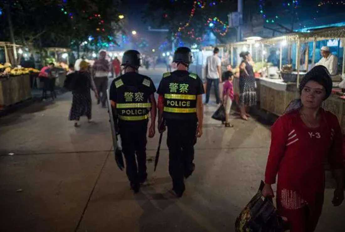 Chinese police patrol a night market near Id Kah Mosque in Xinjiang, a day before the Eid al-Fitr holiday, June 25, 2017. 