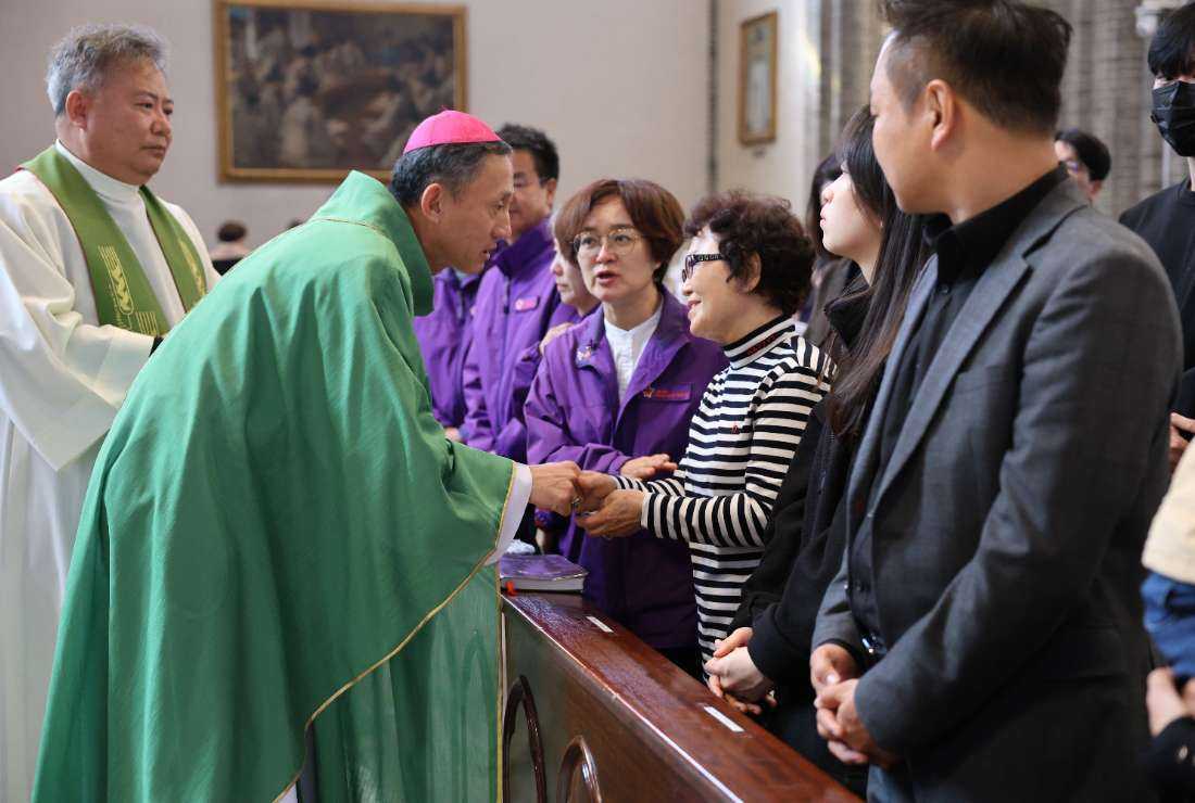 Auxiliary Bishop Timothy Yu Gyeong-chon of Seoul, apostolic vicar for social ministry of Seoul archdiocese, comforts the bereaved families of the Itaewon tragedy victims on Oct. 29 at Myeongdong Cathedral in Seoul. 